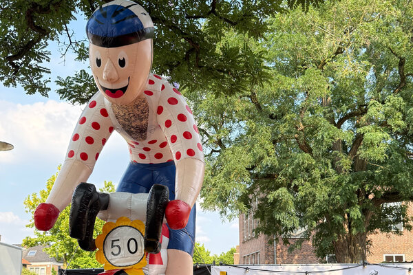 Foto: Renner in bolletjestrui verwelkomt bezoekers aan expositie. 