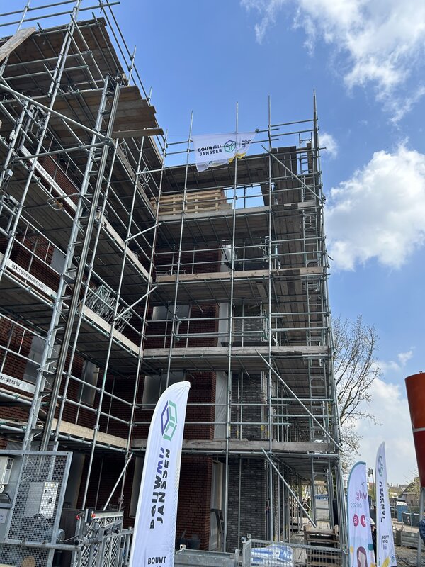 Feestelijk moment op Bakelgeertterrein: vlag wappert op hoogste punt  nieuwbouw 
